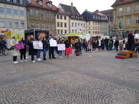 Frauen halten verschiedene Schilder hoch