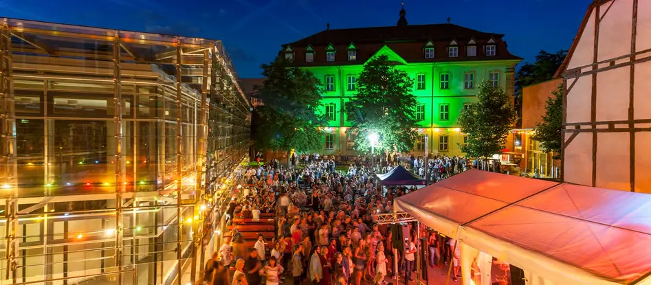 Menschen beim uni.fest im Burgershof abends