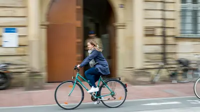 Radfahrerin vor dem Universit?tsgeb?ude Kapuzinerstra?e 25