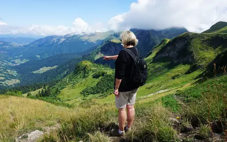 Photo of a seminar member pointing down into the green valley.